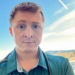Male veterinarian with auburn hair wearing a teal collared shirt